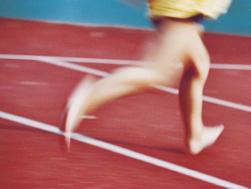 Beine eines Kindes beim schnellen Laufen auf dem Tennisplatz